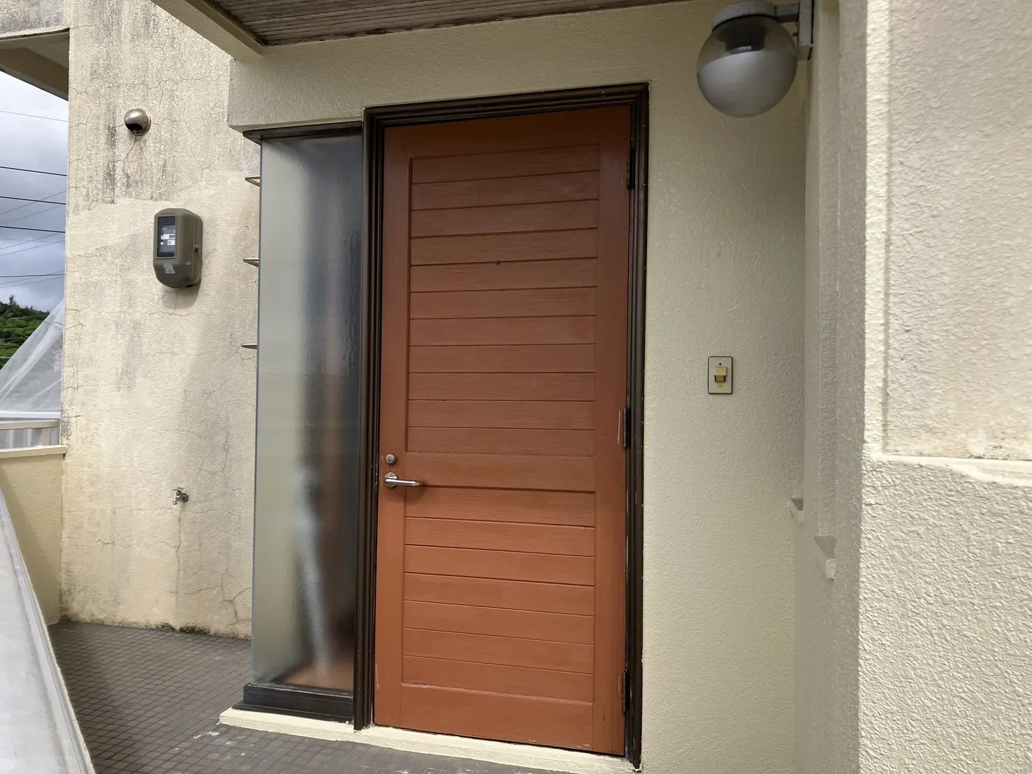 沖縄で施工したリフォーム・那覇で施工したリフォーム施工前の写真：玄関ドア取替工事（カバー工法）